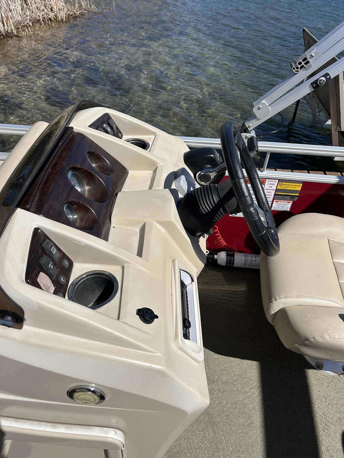 Detailed pontoon helm with wood-look dash and clean cream vinyl