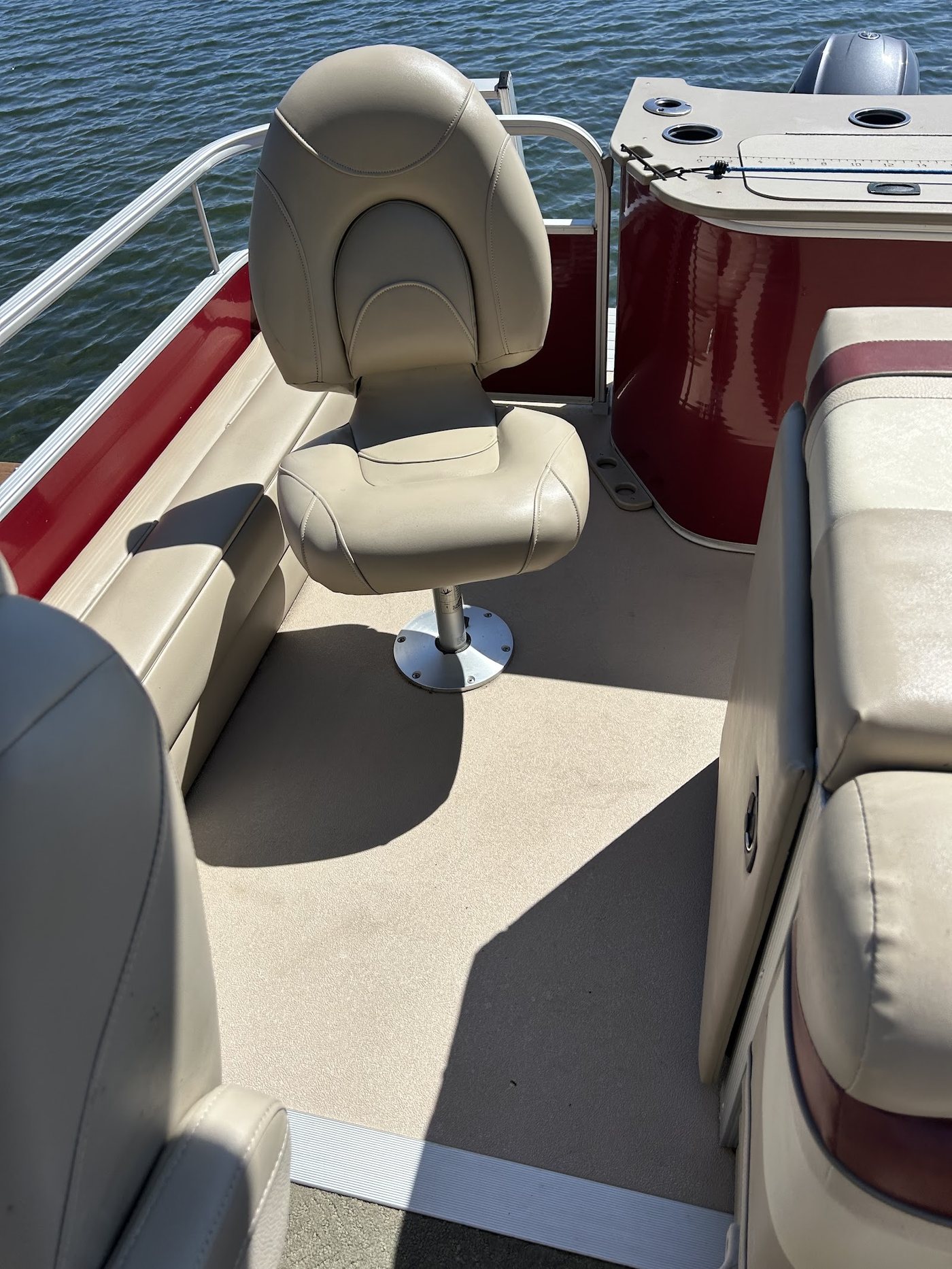 Clean cream vinyl seats and a captain's chair on a pontoon