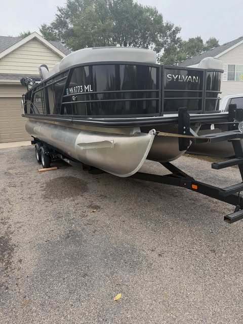 A black Sylvan pontoon on its trailer after a detail