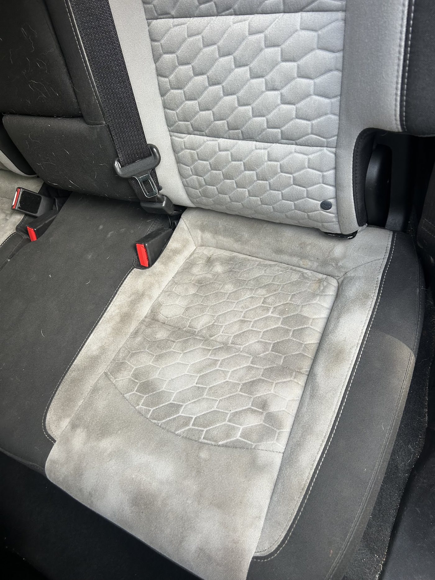 A stained grey cloth truck seat before detailing